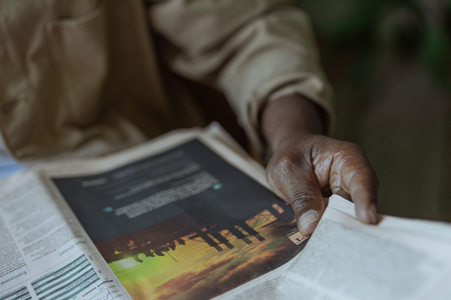Detailed close-up of a person holding and reading a newspaper indoors. — Gap Year Programs for a Meaningful Break Before Coll